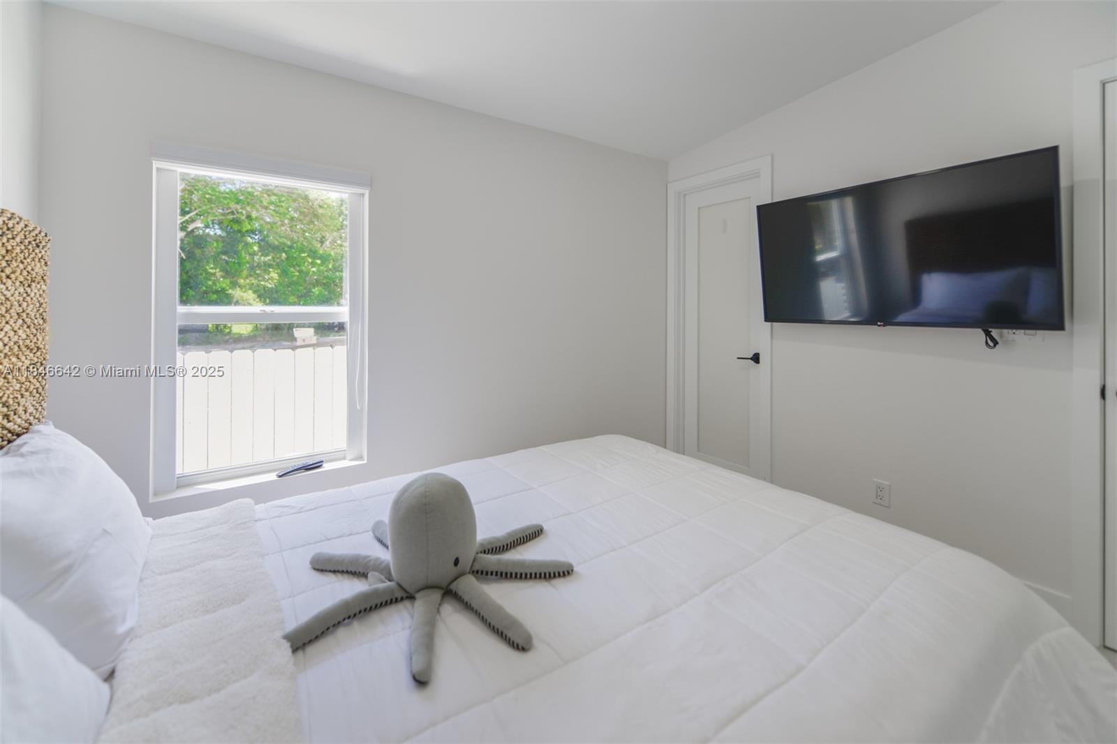 11 Mockingbird Road Key Largo, FL 33037 - Photo 17 of 44 a bedroom with a bed and glass window