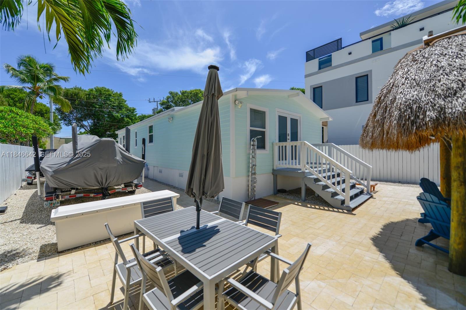 11 Mockingbird Road Key Largo, FL 33037 - Photo 31 of 44 a view of a patio with a table and chairs under an umbrella