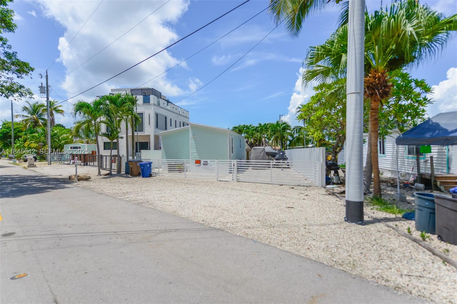 11 Mockingbird Road Key Largo, FL 33037 - Photo 43 of 44 a backyard of a house with plants and tree