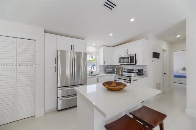 a kitchen with stainless steel appliances a sink a stove and microwave