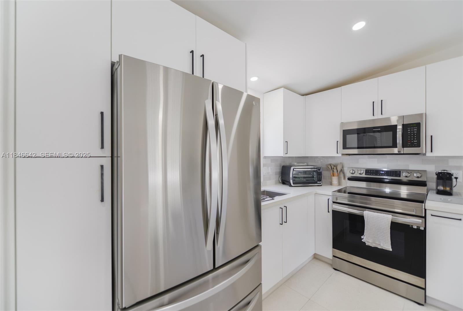 11 Mockingbird Road Key Largo, FL 33037 - Photo 6 of 44 a kitchen with stainless steel appliances a refrigerator stove and microwave