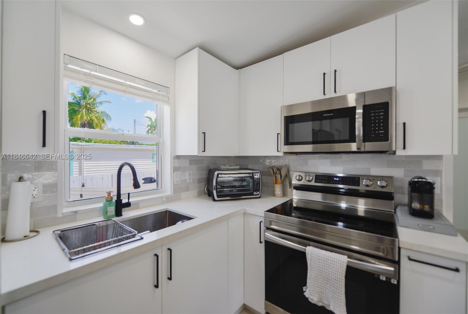 11 Mockingbird Road Key Largo, FL 33037 - Photo 7 of 44 a kitchen with stainless steel appliances a sink a stove and microwave