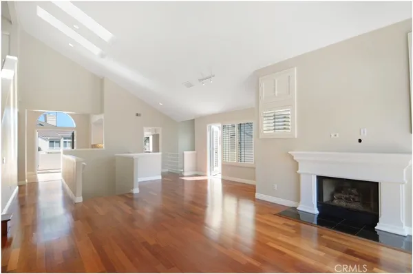 a view of a livingroom with wooden floor and a fireplace