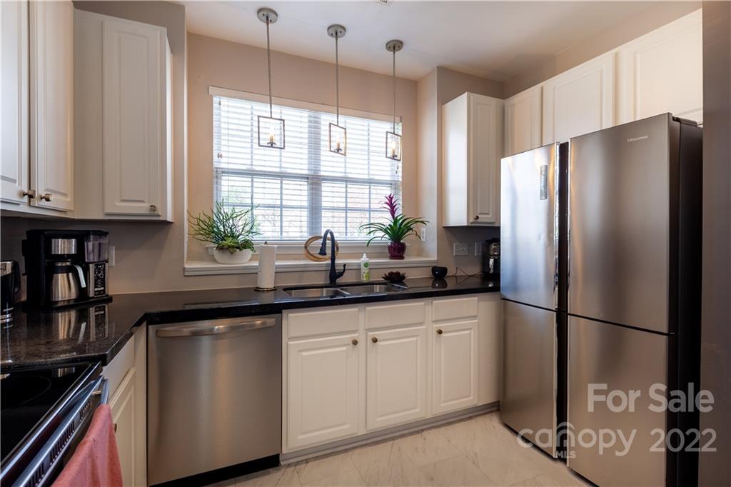 206 Dawn Mist Lane, Unit 28 Fort Mill, SC 29708 - Photo 12 of 39 a kitchen with granite countertop a sink a refrigerator a window and cabinets