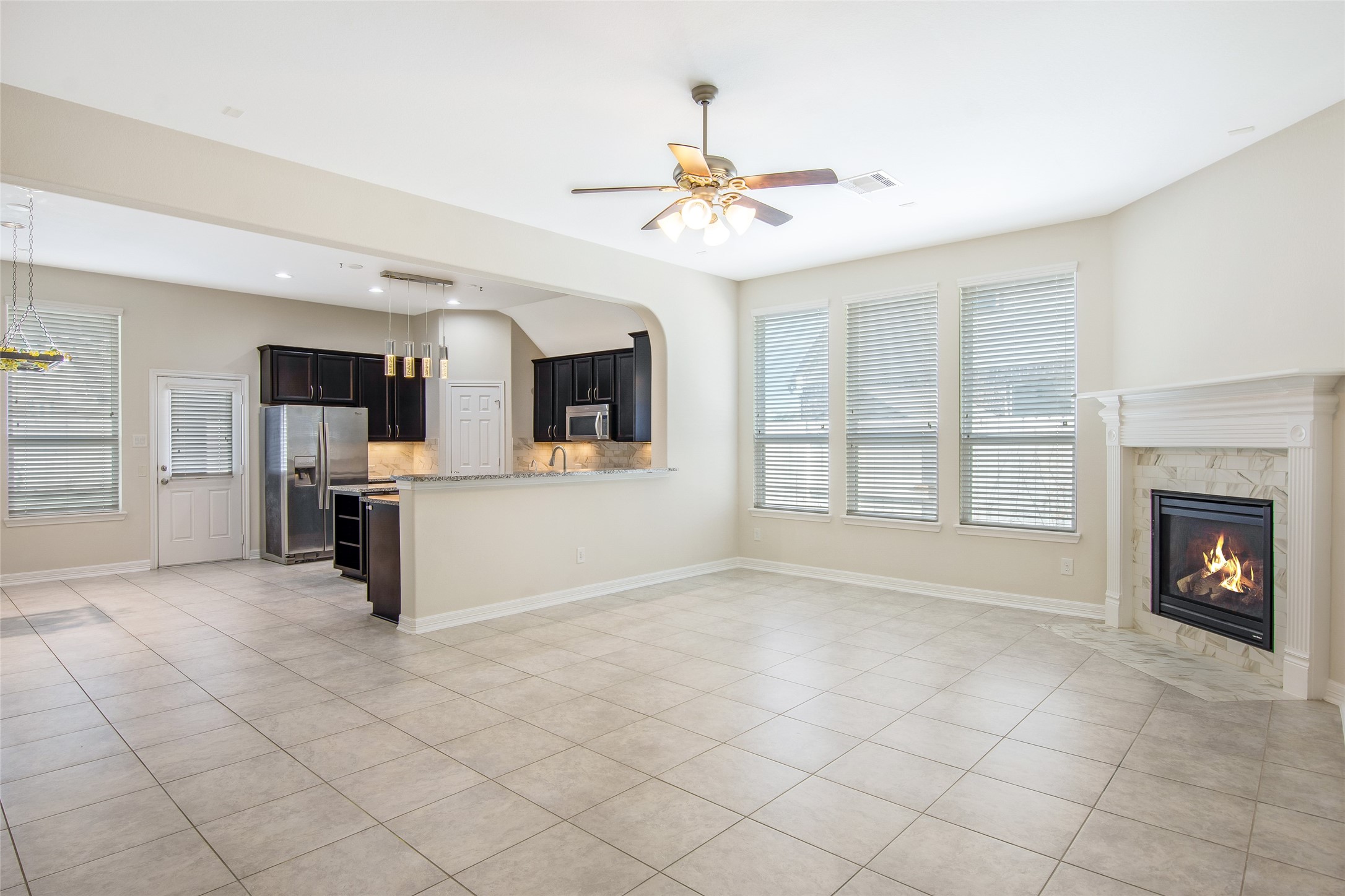 19906 Durwood Pines Lane Cypress, TX 77433 - Photo 26 of 26 a view of a livingroom with a fireplace a chandelier fan and windows