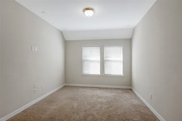 an empty room with fan and windows