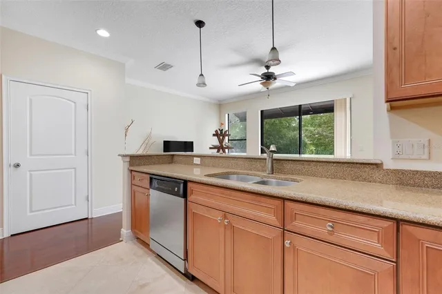 a kitchen with a sink and dishwasher with wooden floor