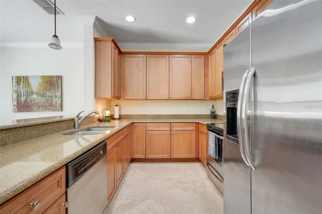 a kitchen with stainless steel appliances granite countertop a sink stove and refrigerator