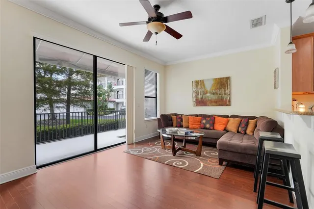a living room with furniture ceiling fan and a window