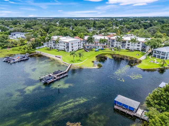 an aerial view of a house with a swimming pool and lake view