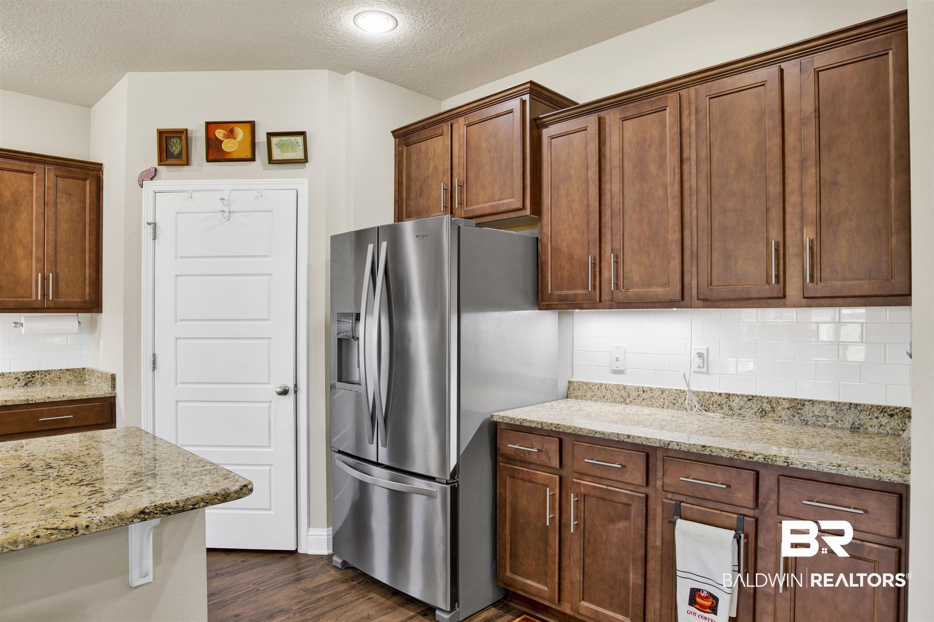 278 Silo Loop Fairhope, AL 36532 - Photo 8 of 26 Kitchen featuring stainless steel fridge, a textured ceiling, backsplash, dark wood-type flooring, and light stone countertops