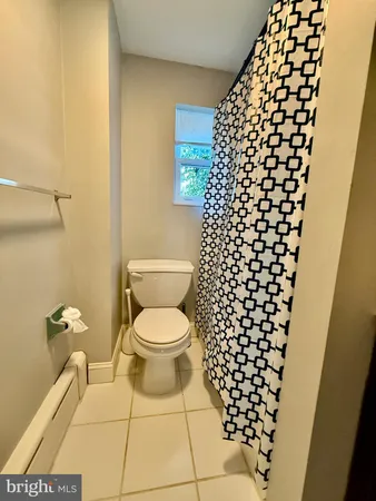a bathroom with a toilet and a shower curtain