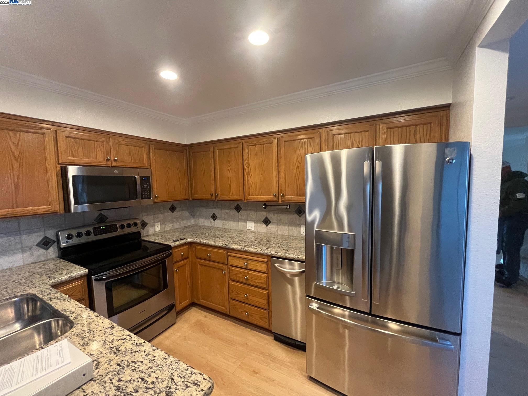 a kitchen with stainless steel appliances granite countertop a refrigerator stove and microwave
