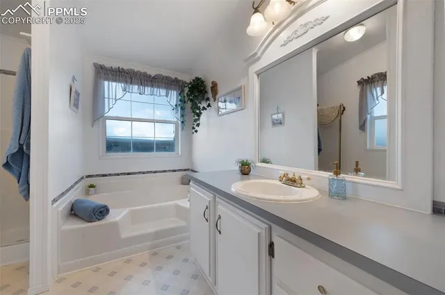 a bathroom with a tub sink and mirror