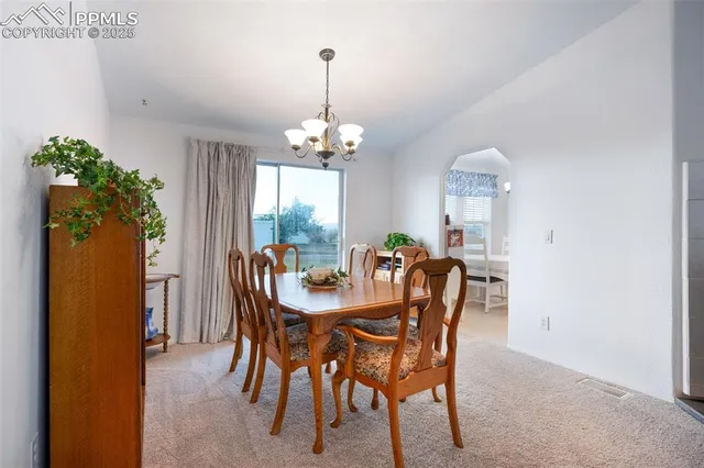 a view of a dining room with furniture and chandelier