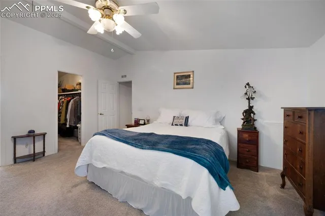 a spacious bedroom with a bed and a chandelier