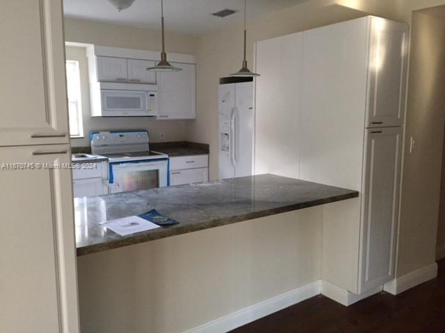 2424 Southwest 21st Street Miami, FL 33145 - Photo 3 of 9 a kitchen with stainless steel appliances granite countertop a sink and a refrigerator