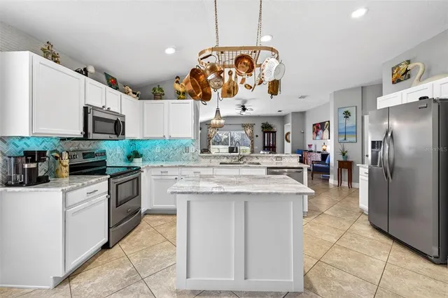 a kitchen with stainless steel appliances granite countertop a refrigerator and a sink