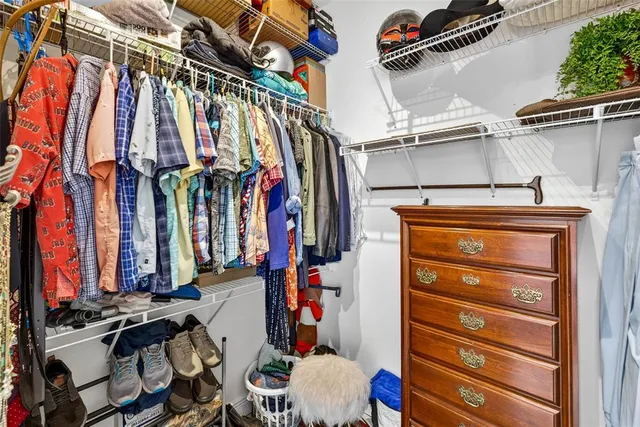 a bedroom with a bed and a flat tv screen on dresser