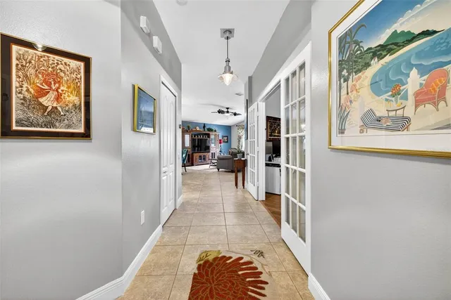 a hallway with painting on the wall and a wooden floor