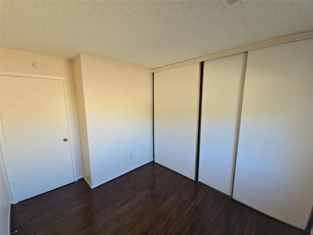 an empty room with wooden floor and sliding door
