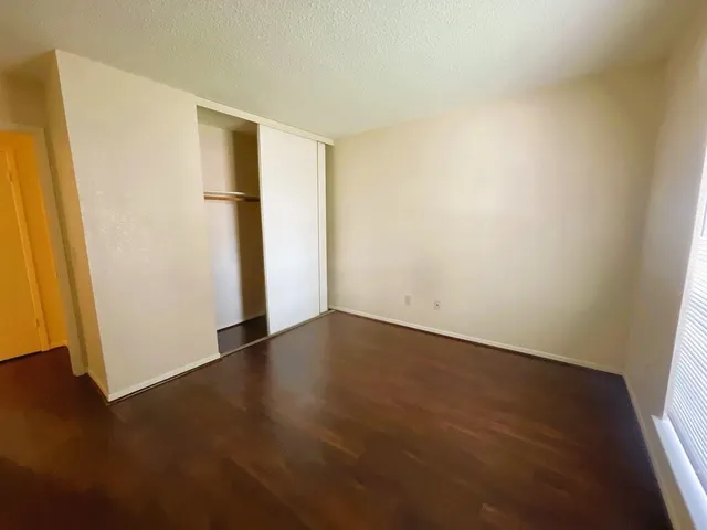 an empty room with wooden floor and closet