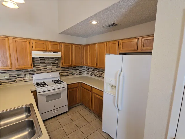 a kitchen with white cabinets and white appliances