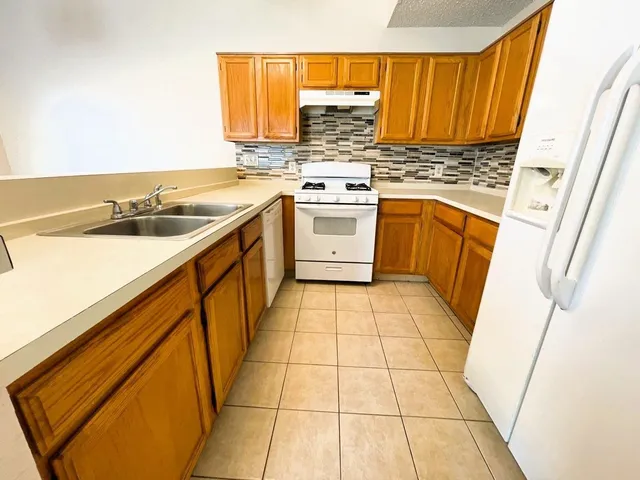 a kitchen with a sink stove and cabinets