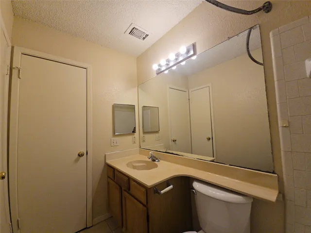 a bathroom with a sink a toilet a mirror and shower
