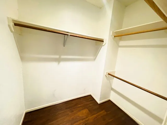 a view of closet with wooden floor