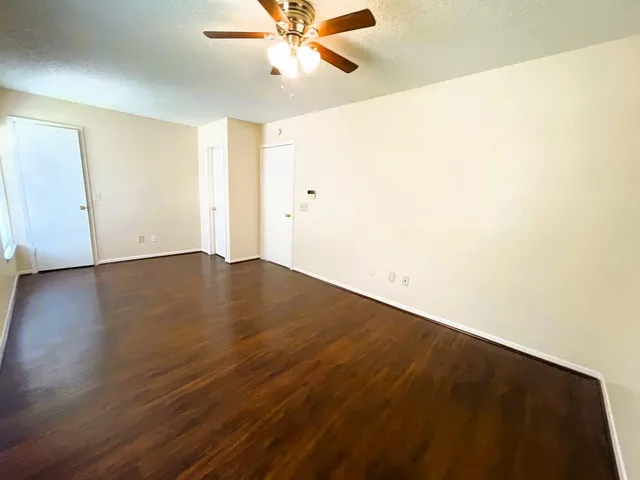 a view of an empty room with wooden floor
