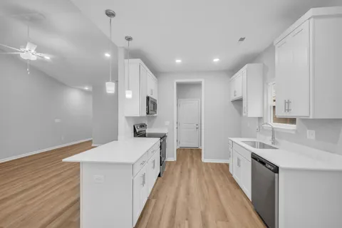 a large kitchen with kitchen island a sink stainless steel appliances and cabinets