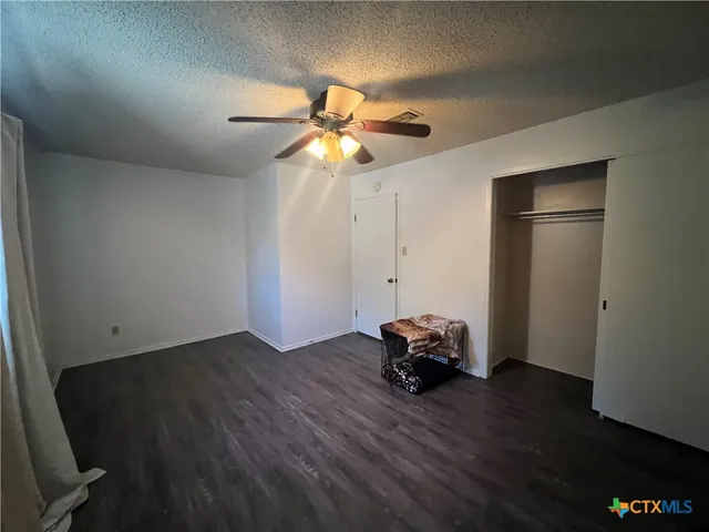 a view of a livingroom with wooden floor and a ceiling fan