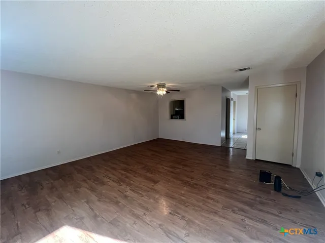 a view of empty room with wooden floor