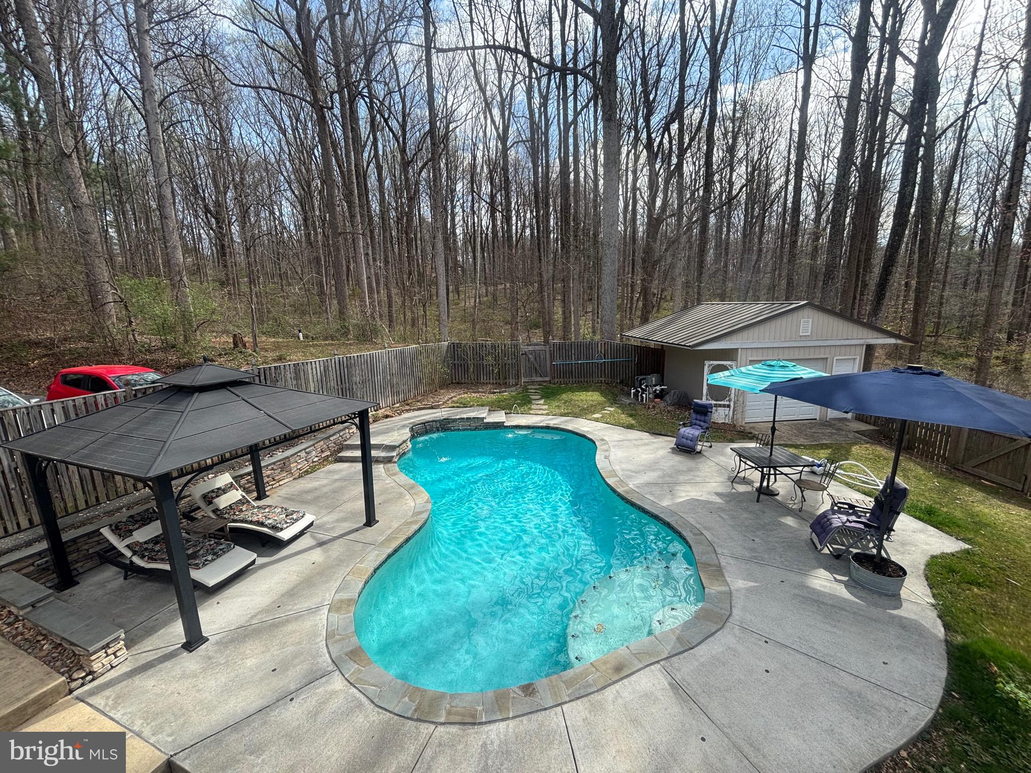 7491 Mink Hollow Road Highland, MD 20777 - Photo 1 of 67 an outdoor sitting area with furniture and umbrella