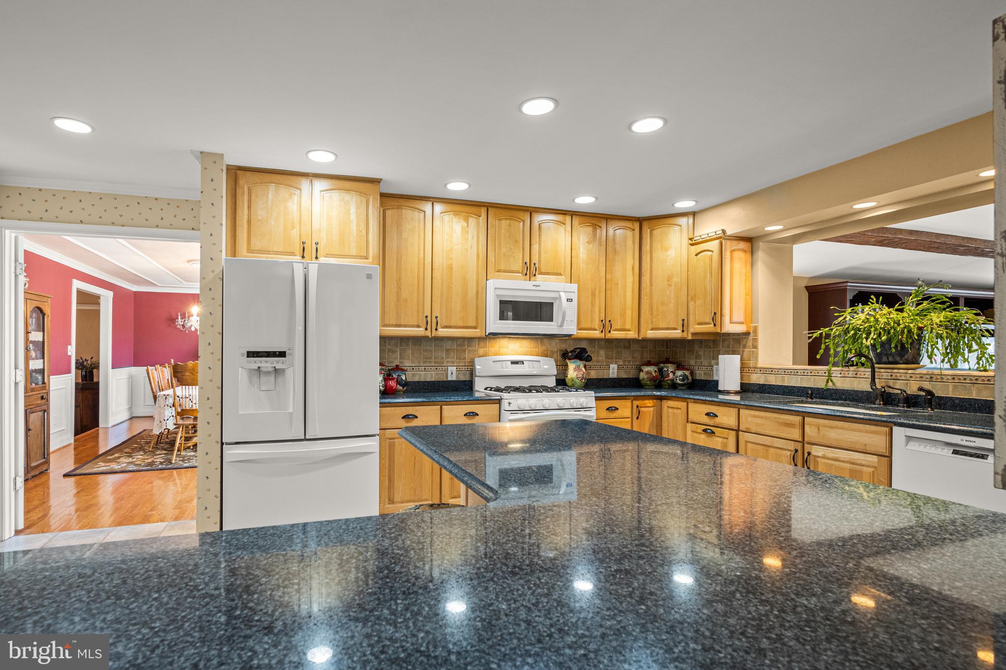 7491 Mink Hollow Road Highland, MD 20777 - Photo 17 of 67 a kitchen with stainless steel appliances granite countertop a refrigerator a stove and a sink with wooden floor