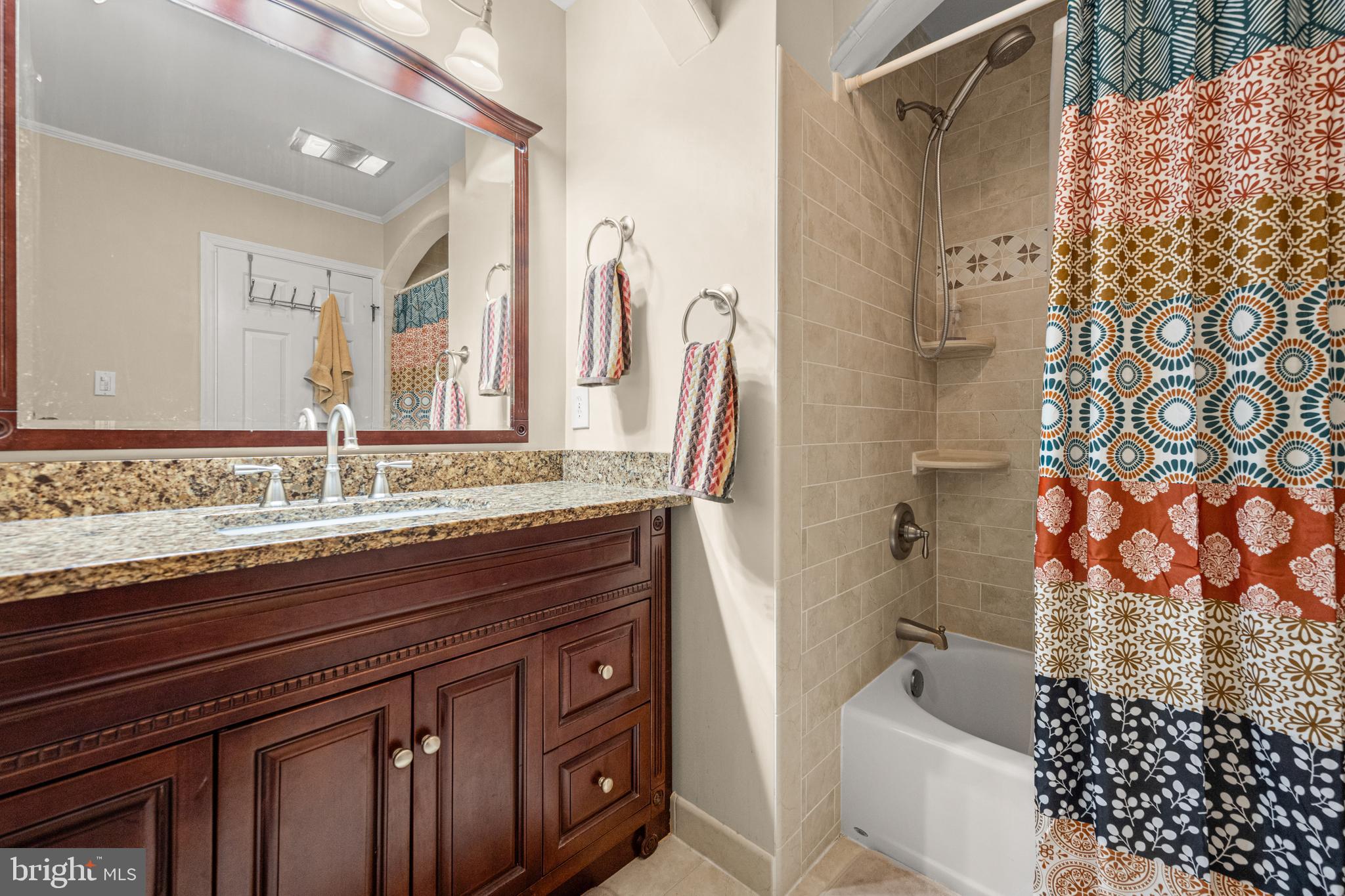 7491 Mink Hollow Road Highland, MD 20777 - Photo 52 of 67 a bathroom with a granite countertop sink a mirror a vanity and a shower
