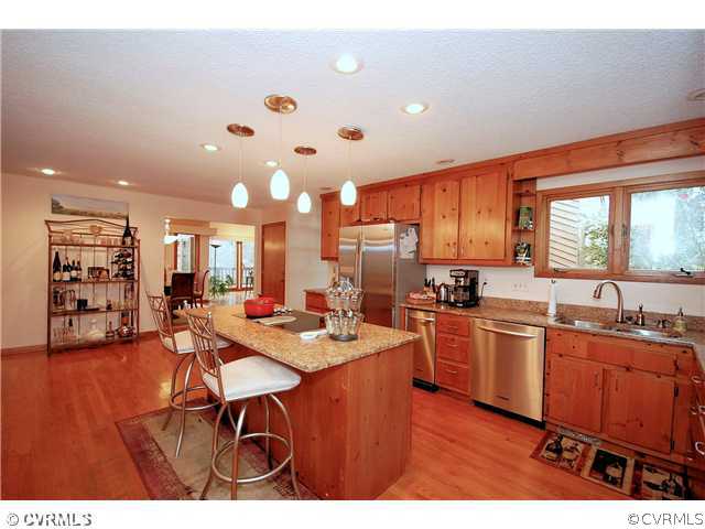 3303 Fortunes Ridge Road Midlothian, VA 23112 - Photo 3 of 12 a open kitchen with stainless steel appliances granite countertop a sink dishwasher a stove a dining table and chairs with wooden floor