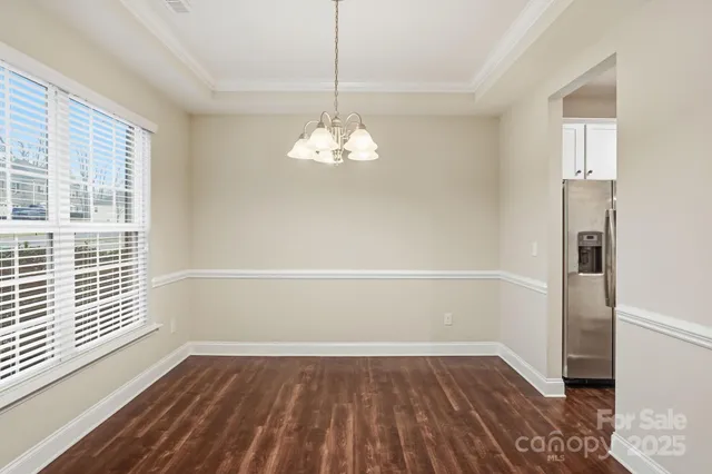 a empty room with wooden floor and windows