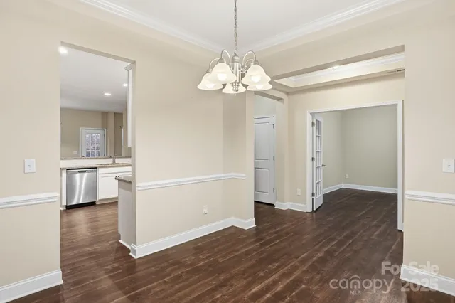 a view of a hallway with wooden floor and a kitchen