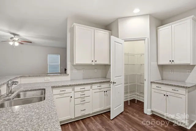 a kitchen with white cabinets and sink