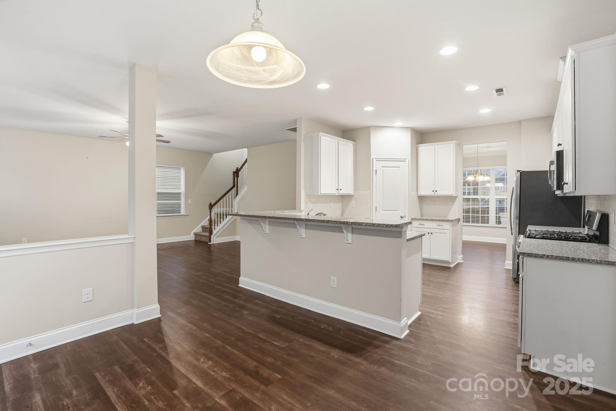 182 Sassafras Road Mooresville, NC 28115 - Photo 7 of 47 a kitchen with stainless steel appliances granite countertop a refrigerator a stove and a wooden floors