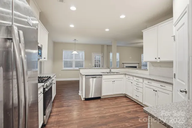 a kitchen with stainless steel appliances granite countertop a stove a sink and a refrigerator