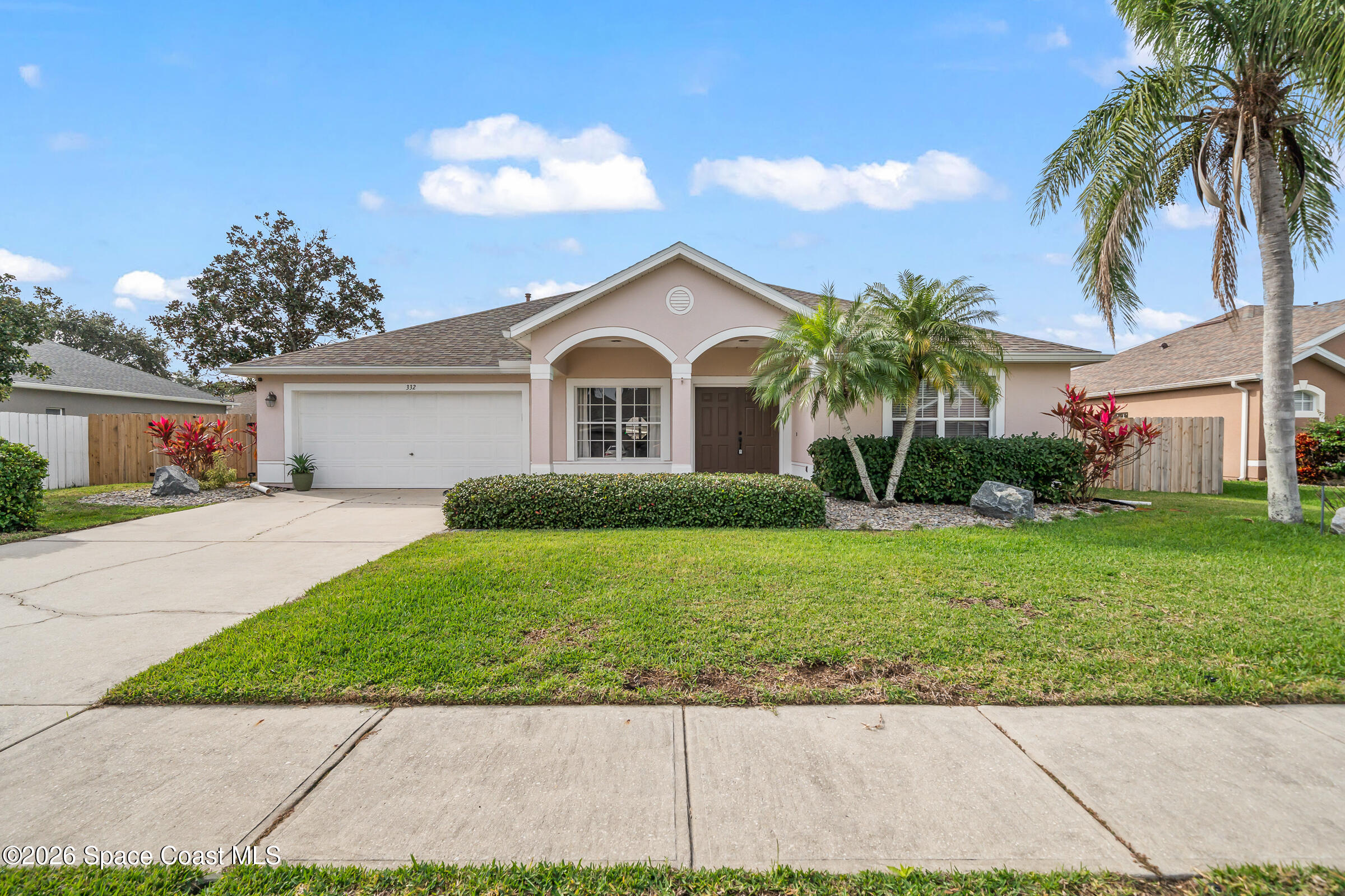 332 Brookcrest Circle Rockledge, FL 32955 - Photo 2 of 38 a front view of a house with a garden and trees