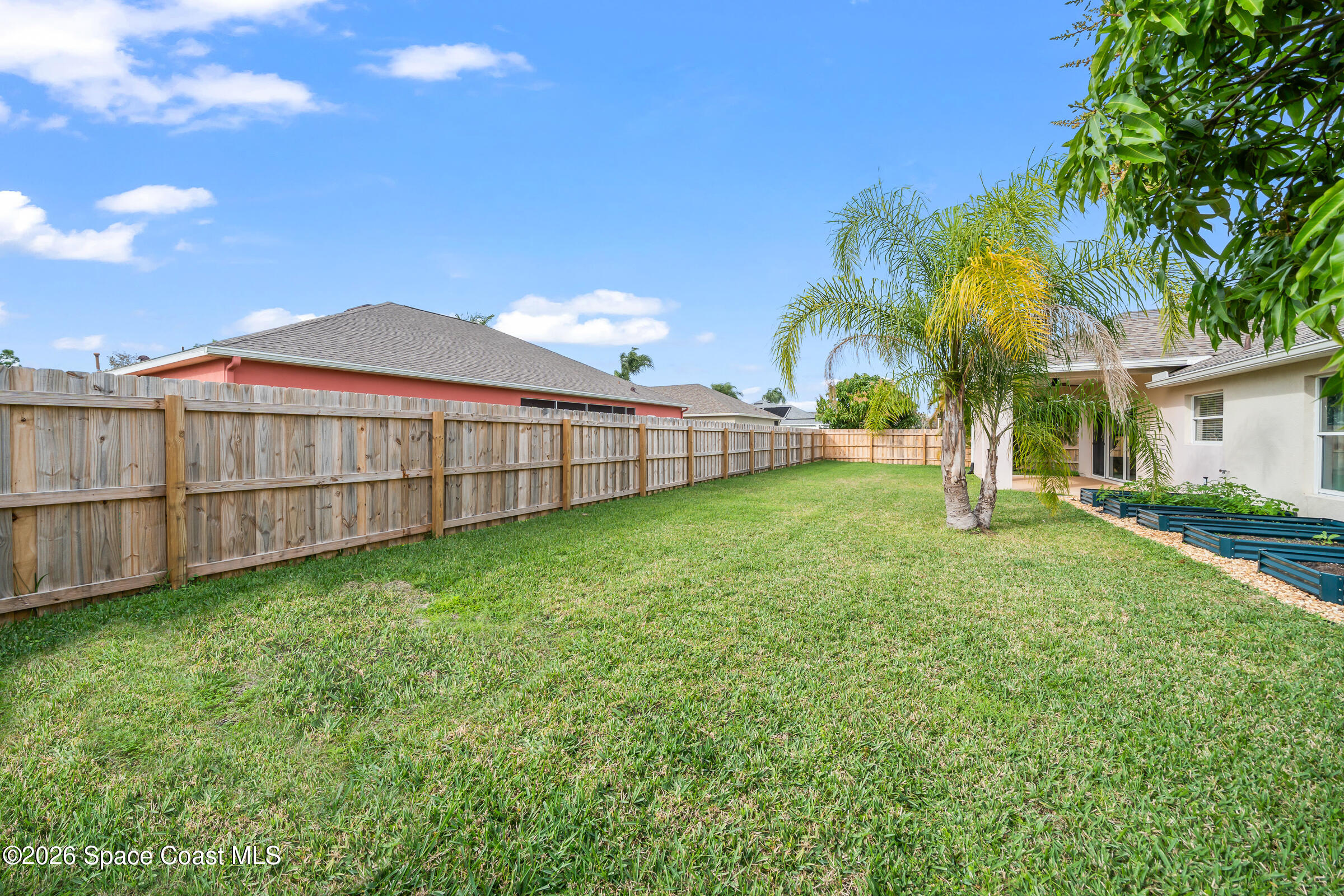 332 Brookcrest Circle Rockledge, FL 32955 - Photo 38 of 38 a view of a backyard with a garden and palm trees