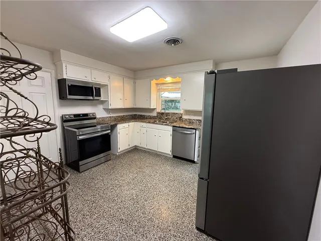 a kitchen with stainless steel appliances granite countertop a stove a sink and a refrigerator