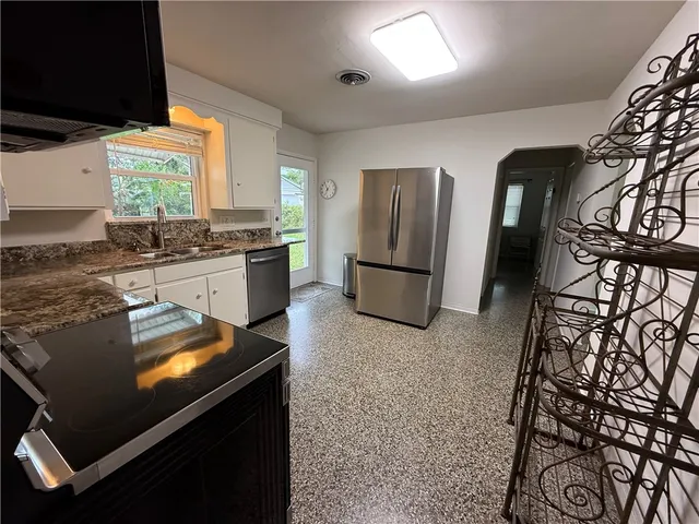 a kitchen with sink stove and refrigerator