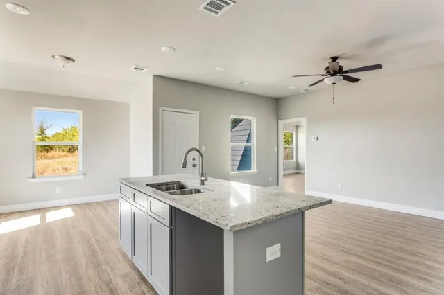 a bathroom with a granite countertop sink a mirror and shower