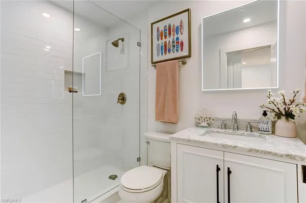 a bathroom with a granite countertop sink toilet and shower