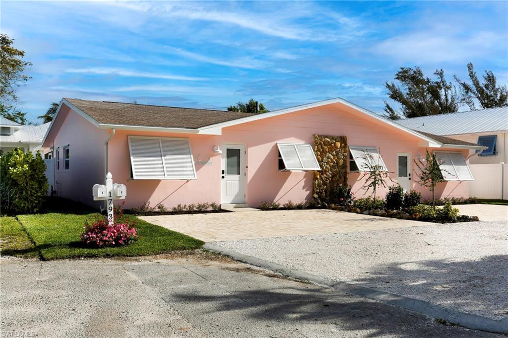 1793 Smugglers Cove, Unit B Naples, FL 34112 - Photo 2 of 24 a front view of a house with a yard